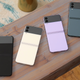 A photo of each of the colors of Galaxy Z Flip 3 face down on a plank of wood